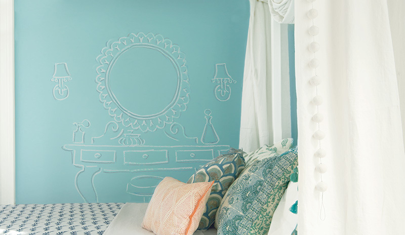 Una pared de pizarra azul claro hace un acento divertido en el dormitorio de un niño.