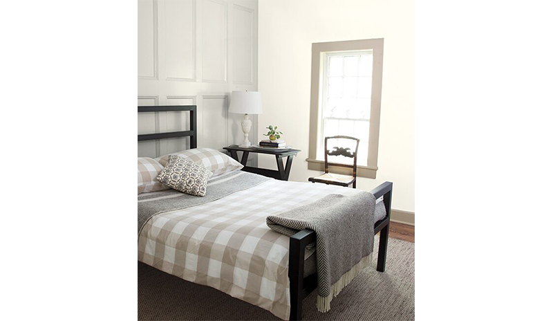 Relaxing bedroom with gray wainscoting behind black bed with gray and white checkered bedding.