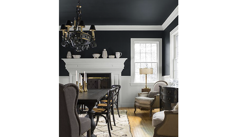 Amplio comedor con espectaculares paredes negras, techo y molduras blancas.