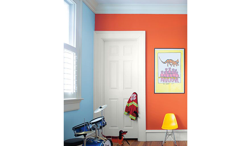 A kid’s room with one orange wall and one blue, white trim and doors.