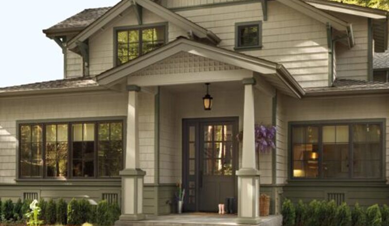 A beautiful taupe-painted Craftsman style home with gabled rooflines and a front porch