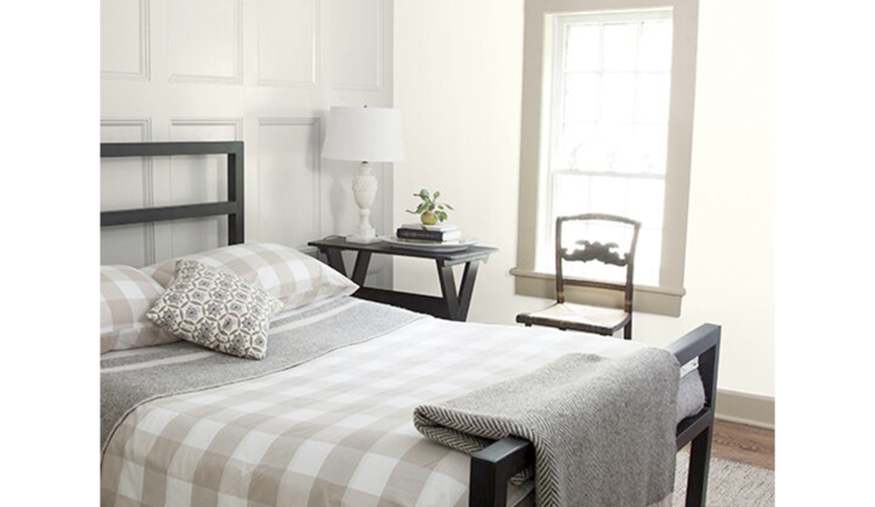 Un dormitorio blanco con paredes paneladas pintadas en Classic Grey OC-23.