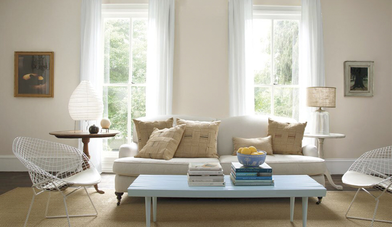 Sala de estar moderna y abierta con paredes neutras claras y muebles de estilo mixto
