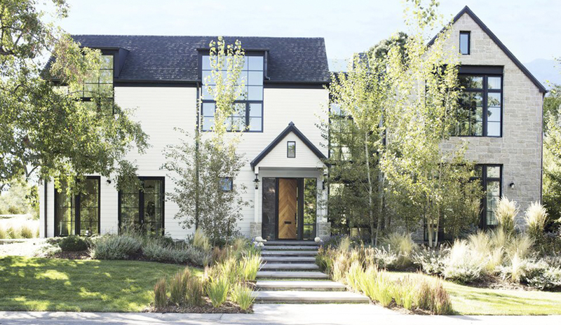 Casa moderna de estilo rústico con exterior blanco y adornos oscuros.