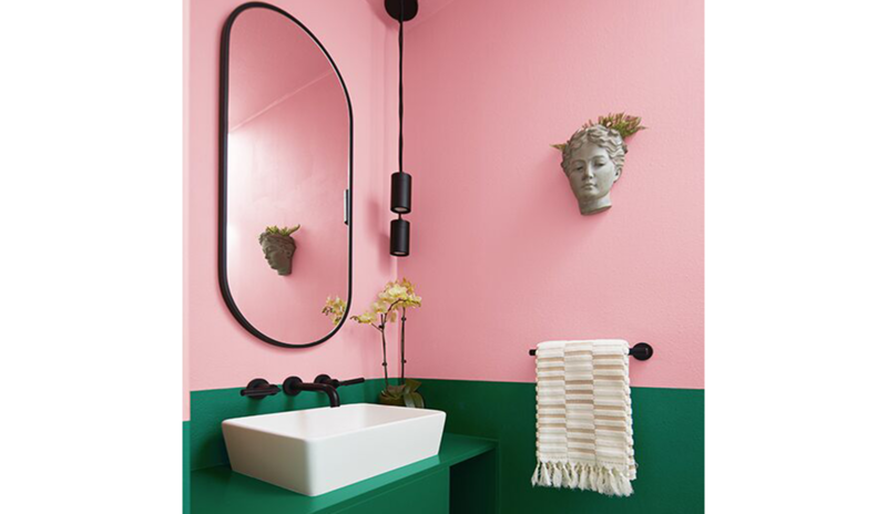 Small powder room with a split wall featuring a saturated pink and forest green