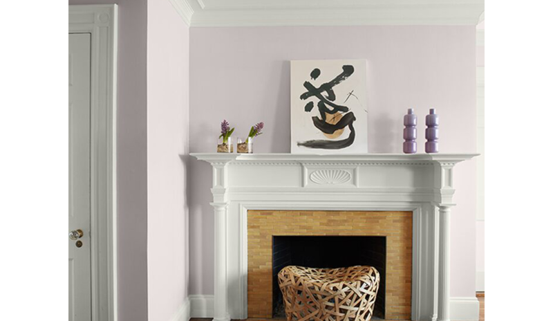 Bonitas paredes de esquina pintadas de violeta claro, molduras de techo y repisa de chimenea blancos