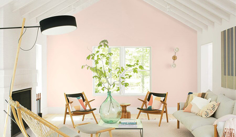 Sala de estar vibrante con techos con vigas blancas y una pared decorativa pintada de rosa claro