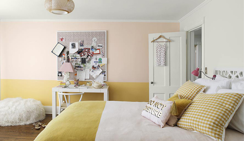 Dormitorio pintado en Soft White y Hawthorne Yellow  con un sillón, tablero de corcho desordenado
