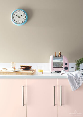 Una cocina pálida con armarios rosados pintados con el color del año 2020 de Benjamin Moore