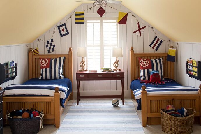 Top floor nautically themed kids room with yellow angled ceiling and matching bed room set.