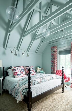 Dormitorio azul suave con vigas de techo geométricas expuestas.