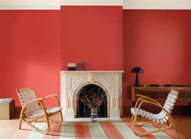 Sala de estar con paredes pintadas de color rojo Raspberry Blush, chimenea de mármol blanco.
