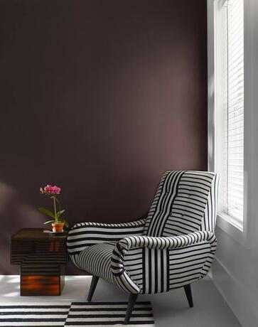 Pared decorativa pintada de marrón wengué en una sala de estar pintada de White Heron con una silla 