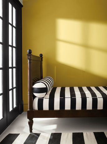 Dormitorio pintado de Savannah Green con puertas  de color Onyx, cama de madera y suelo blanco.
