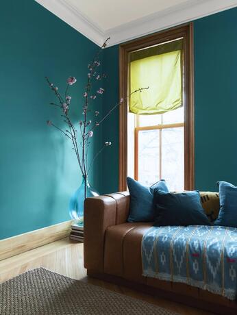 Sala de estar pintada en North Sea Green con molduras White Heron y techo de blanco roto Etiquette.
