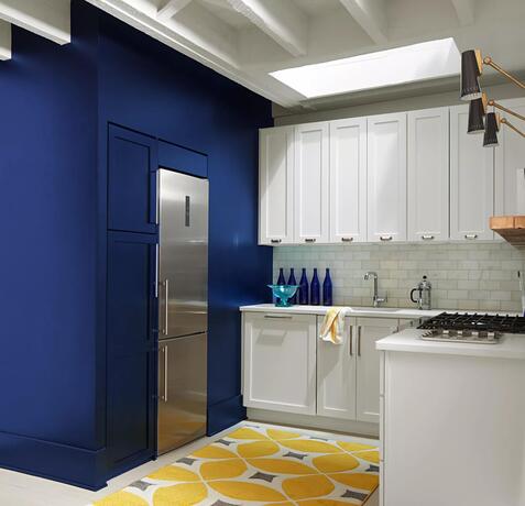 Pared decorativa pintada en Starry Night Blue en una cocina con gabinetes pintados en White Heron.