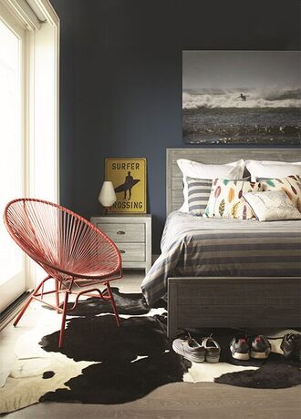 A dark rich blue bedroom with surfer-inspired décor.