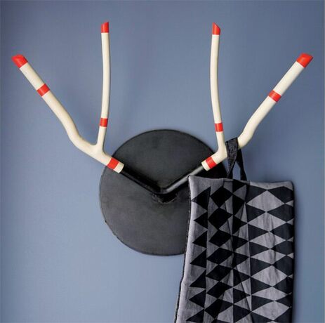 A black and grey scarf hangs on antler coat hooks against a blue wall.