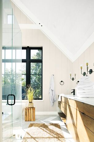 Un baño amplio y luminoso pintado en colores neutros y blancos.