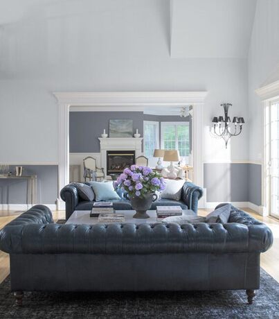 Una serena sala de estar con una combinación de pintura blanca y gris cuenta con dos grandes sofás.