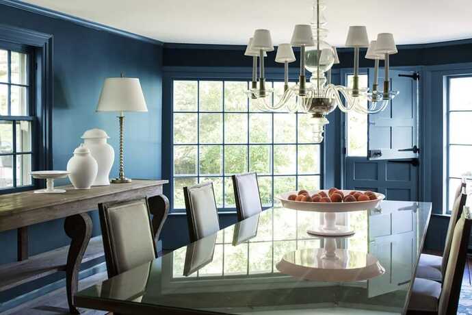 Un comedor completamente azul con puerta francesa y mesa de comedor rectangular de alto brillo.