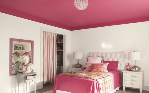 Paredes blancas de dormitorio con techo rosa brillante y ropa de cama rosa.