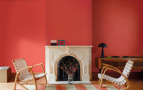 Living room with Raspberry Blush red-painted walls, white marble fireplace and relaxed seating.