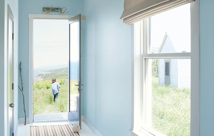 Hallway walls with light blue Breath of Fresh Air 806 color, white trim, and open door.