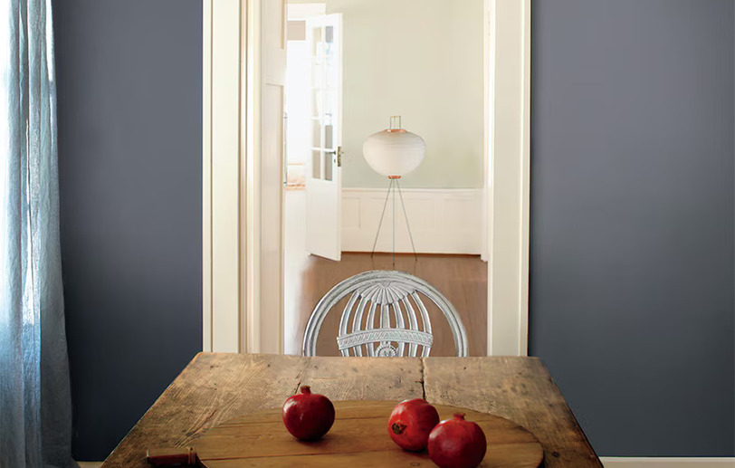 Rustic plank table with gray-blue wall and pomegranates Rustic plank table with gray-blue wall and pomegranates