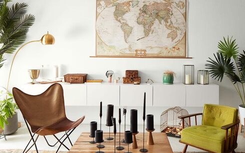 Bright loft living room with white walls, world map, modern cabinetry, leather butterfly chair