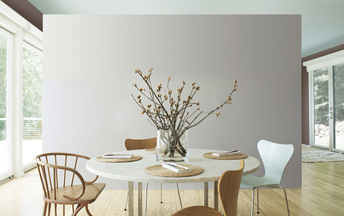Amplia cocina con paredes en gris y techo color menta; Mesa circular con sillas de madera.